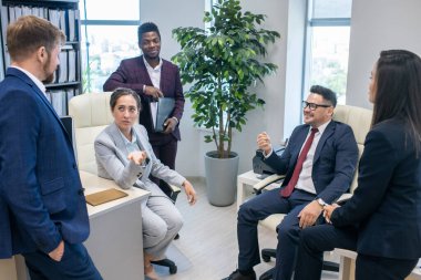 Kültürler arası meslektaşlar ofiste tartışıyorlar.