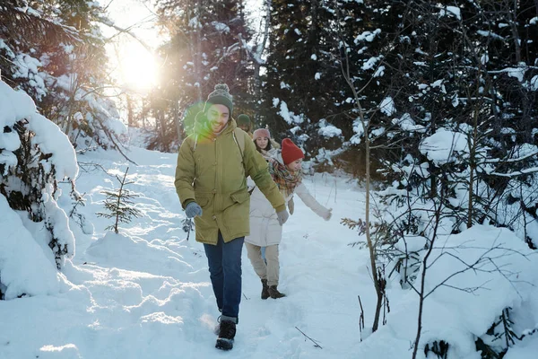 Happy young backpackers moving down snowdrift in the forest — Stock Photo, Image