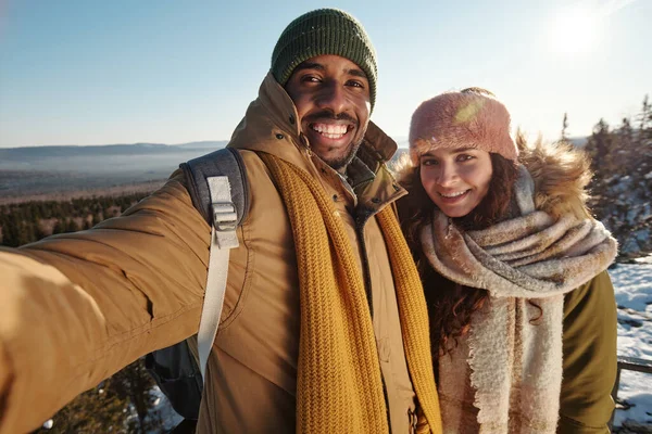 Szczęśliwa wielorasowa para robi selfie przeciwko środowisku naturalnemu — Zdjęcie stockowe