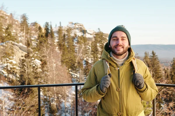 Ung glad manlig resenär med ryggsäck njuter vintern resa — Stockfoto