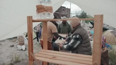 Çadırda kötü koşullarda yaşayan evsiz ve mülteciler gibi çeşitli insanlara su, yiyecek ve sıcak giyecek sağlayan gönüllülerden oluşan orta ölçekli bir ekip.