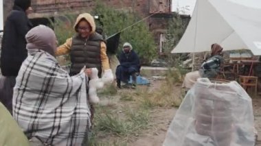 Sıcak giyimli, içi doldurulmuş eski oyuncaklarla dolu neşeli Afro-Amerikan bir kızın fotoğrafını çekiyorum. Annemin yanına koşuyorum, kucaklaşıyorum, göçmen çadırında diğer göçmenlerle yaşıyorum.