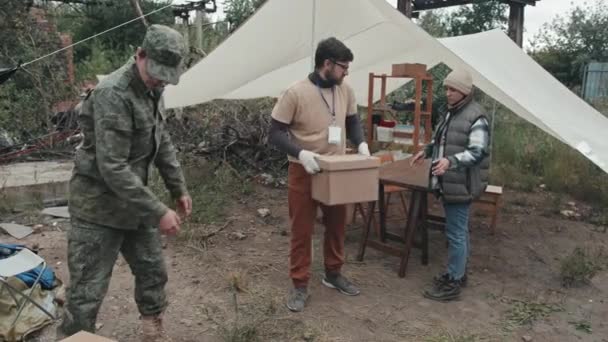 Disparo Completo Oficial Policía Uniforme Militar Pasando Cajas Donación Cartón — Vídeos de Stock