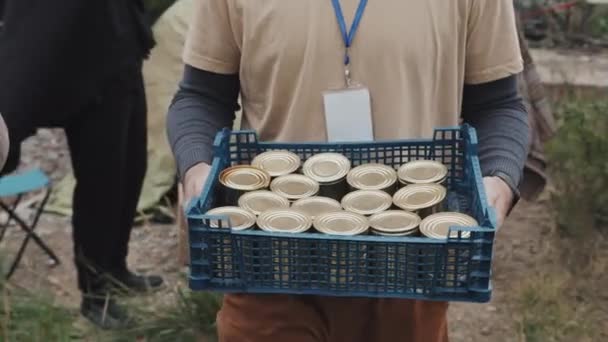 Tanımlanamayan Erkek Sosyal Hizmet Görevlisinin Konserve Yiyeceklerle Dolu Plastik Sandık — Stok video