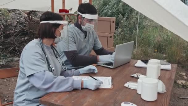 Tiro Médio Dois Trabalhadores Médicos Roupas Proteção Escudos Faciais Máscaras — Vídeo de Stock