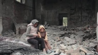 İki küçük Afro-Amerikalı evsiz kızın yıkılmış evlerinin yıkıntıları üzerinde otururken çekilmiş bir fotoğrafı.