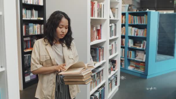 Lentitud Media Estudiante Universitaria Asiática Parada Entre Estanterías Biblioteca Contemporánea — Vídeo de stock