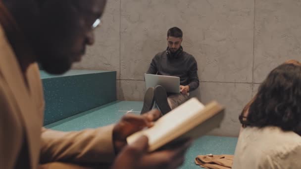대학생들 실내의 청록색 계단에서 공부하는 느림보 헤드폰을 노트북 컴퓨터를 젊은이 — 비디오