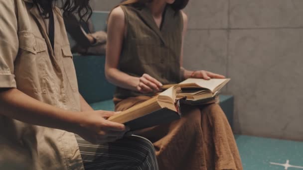 中区Slowmoショットの2人の認識できない女子大生上の階段本のページをめくりながら勉強 — ストック動画