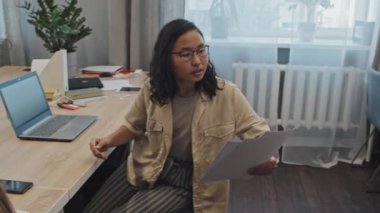 Girişimci genç, çok ırklı ofis çalışanlarından oluşan bir ekip iş yerindeki iş belgelerini tartışıyor. Erkek arkadaşları herkese hazır kahve getiriyor.
