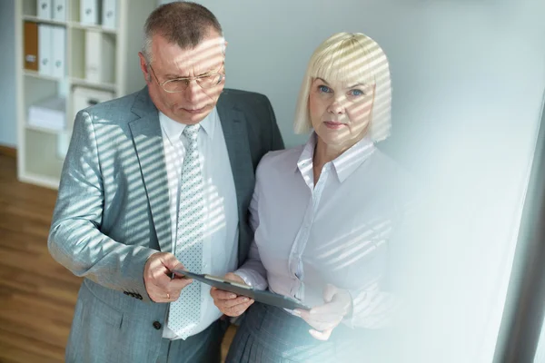 Reifer Geschäftsmann schaut sich Dokument an — Stockfoto