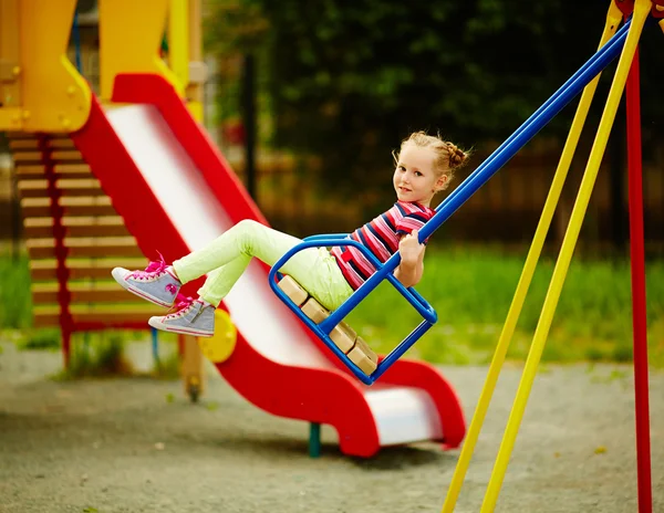 Chica balanceo en el patio de recreo — Foto de Stock