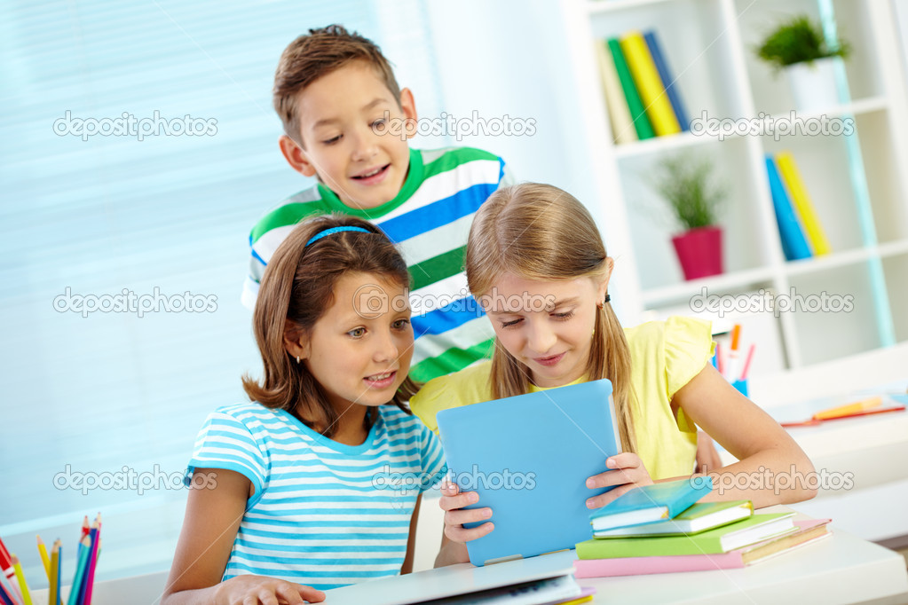 Classmates using digital tablet
