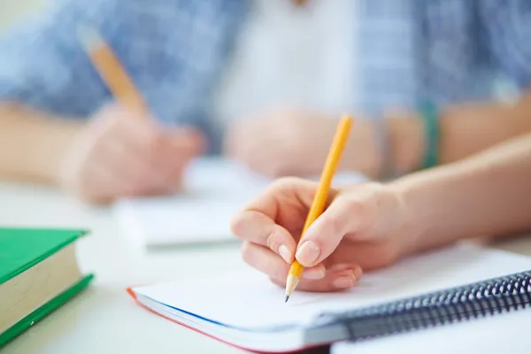 Student erledigt schriftliche Aufgabe — Stockfoto