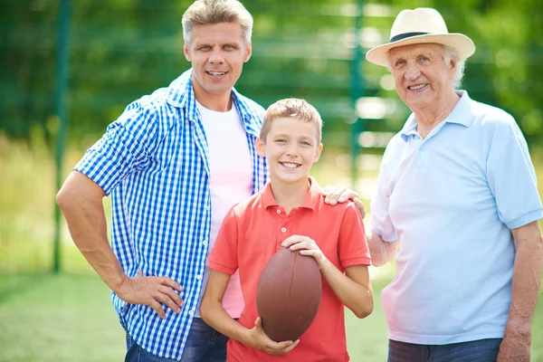 Мальчик с мячом для регби, дедушка и отец — стоковое фото