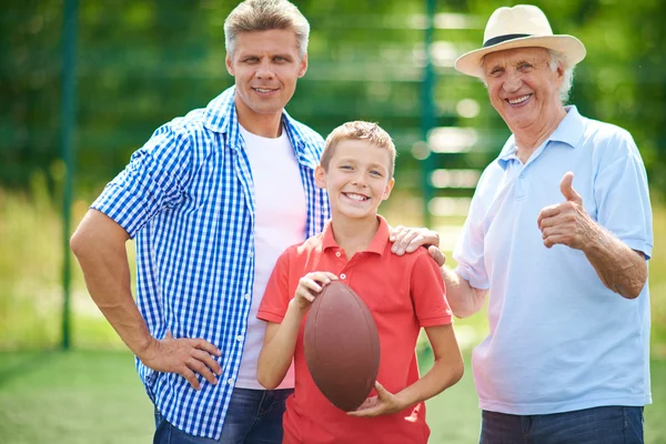 Pojke med rugby boll, farfar och far — Stockfoto