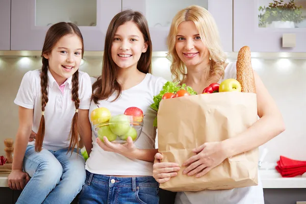 Moeder en twee dochters in keuken — Stockfoto