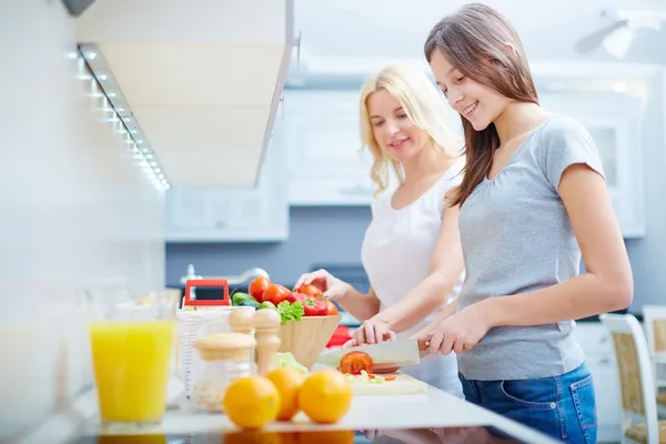 Meisje en haar moeder koken in de keuken — Stockfoto