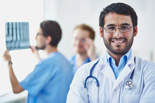 Glimlachende dokter kijkend naar camera — Stockfoto