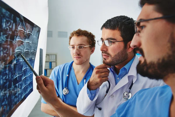 Doctors looking attentively at x-ray — Stock Photo, Image