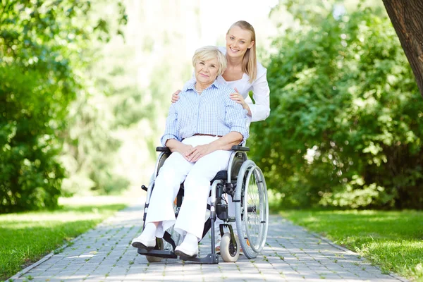 Infirmière et patiente âgée en fauteuil roulant — Photo