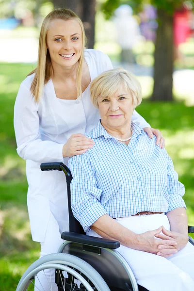 Νοσοκόμα και ανώτερος ασθενή σε μια αναπηρική καρέκλα — Φωτογραφία Αρχείου