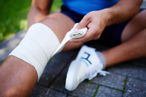 Man bandaging leg — Stock Photo, Image