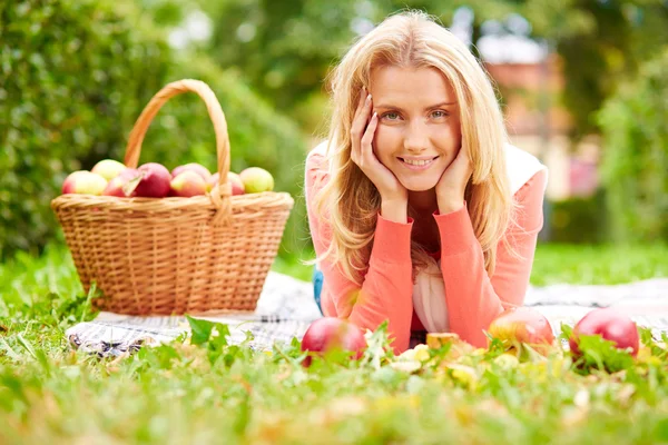 Meisje met appels liggen op gras — Stockfoto