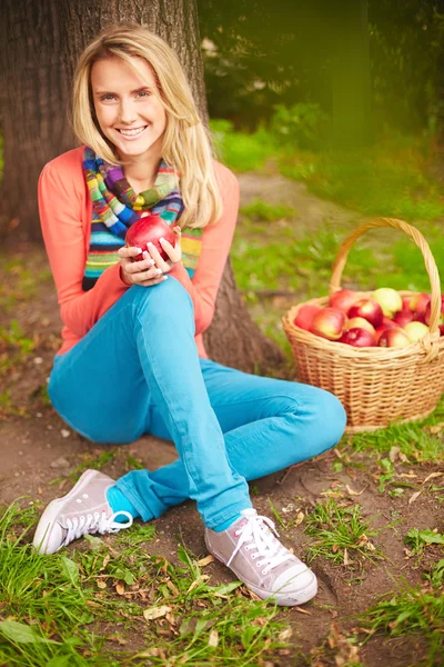 Chica con manzana sentada en el suelo — Foto de Stock