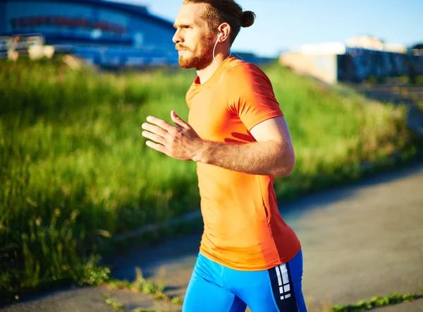 Sportsman with earphones running — Stock Photo, Image