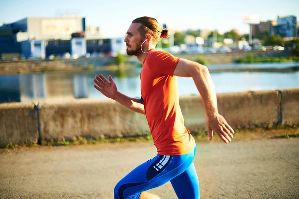 Sportsman with earphones running — Stock Photo, Image