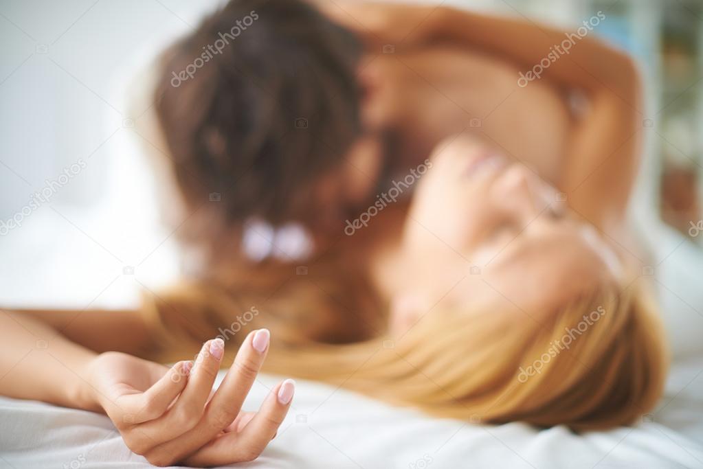 Female lying on bed with man