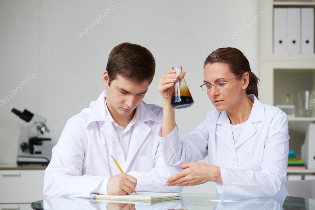 Scientists making analysis of liquid