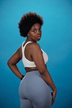 Aktif giyimli ciddi bir kadın sana bakıyor.