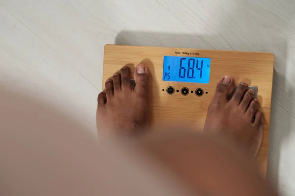 Feet of barefoor woman standing on scales — Stock Photo, Image