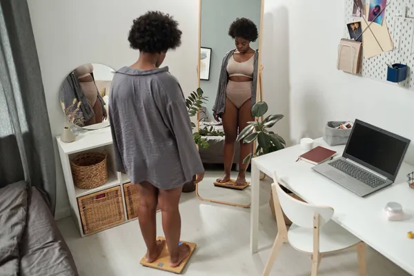 Africana más tamaño femenino de pie en escamas en el dormitorio —  Fotos de Stock