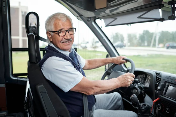Zadowolony kierowca autobusu międzymiastowego trzymający kierownicę — Zdjęcie stockowe
