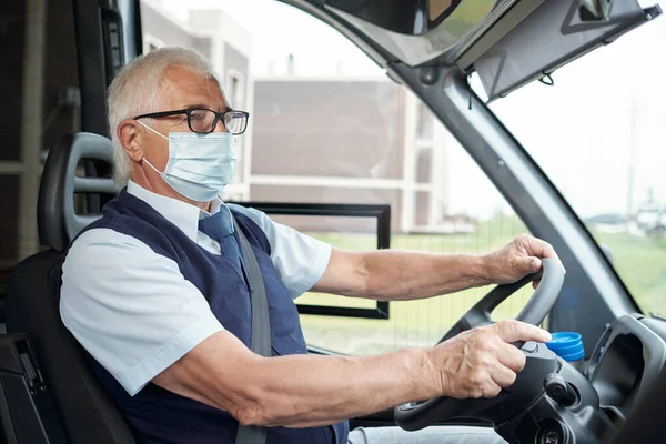 Vezető buszvezető baleseti viseletben, szemüvegben és védőmaszkban — Stock Fotó