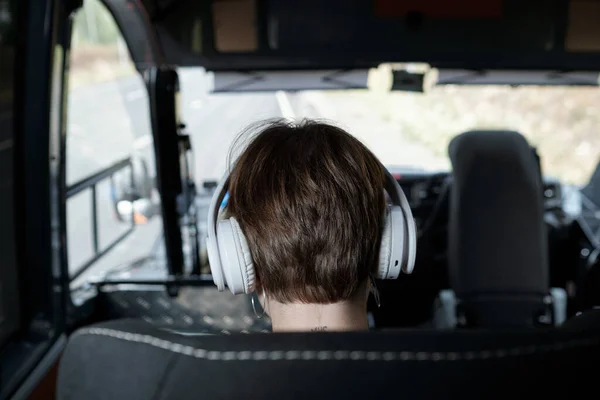 Vista trasera de la cabeza de la chica en los auriculares que viajan en autobús — Foto de Stock