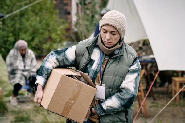 Młoda kobieta niosąca pudełko z ubraniami dla uchodźców — Zdjęcie stockowe