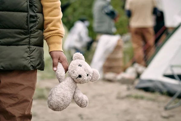 Hand of homeless child holding white teddybear — Stock Photo, Image