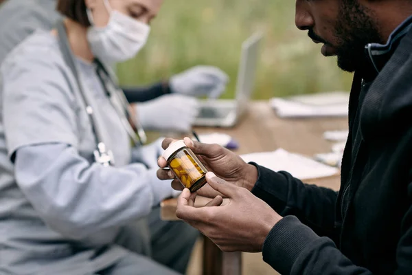Молодой больной человек держит бутылку с таблетками, прописанными врачом — стоковое фото