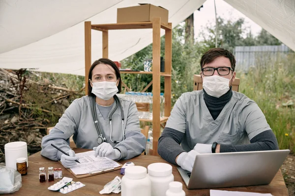 Twee handschoen clinicus in uniform werken aan tafel — Stockfoto