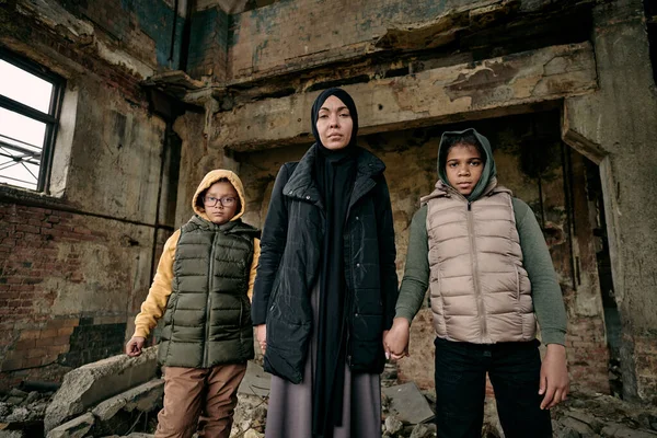 Joven musulmana sosteniendo a sus dos hijas por las manos —  Fotos de Stock