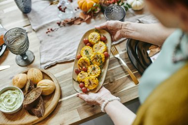 Tabağı masaya servis eden kadın.
