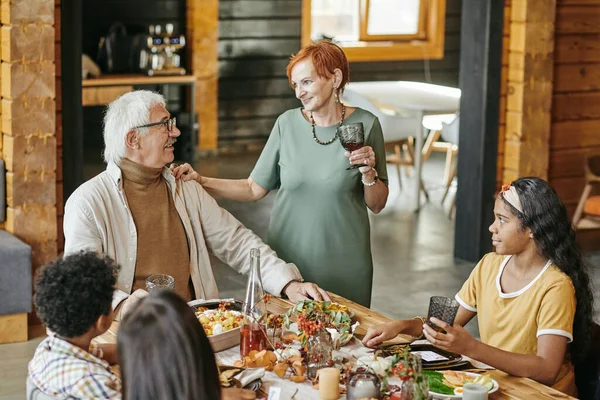 Mor- och farföräldrar äter tillsammans med barnbarn — Stockfoto