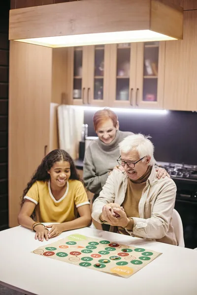 Щасливі бабусі і дідусі грають з онукою — стокове фото