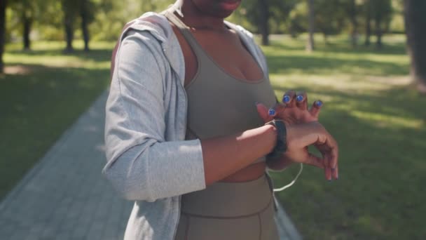 一名身穿运动服的非洲裔美国妇女在公园里慢跑时 手腕上戴着漂亮的套鞋 拍摄了一张无法辨认的慢镜头 — 图库视频影像