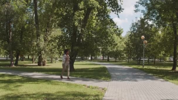 阳光灿烂的一天 年轻活跃的非洲裔美国女子在公园里穿着运动服慢跑时的慢镜头 — 图库视频影像
