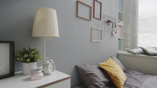 没有人在墙上挂着灰色墙壁 舒适的床和相框的现代舒适居室的室内设计中慢镜头 — 图库视频影像